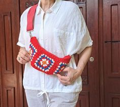 an older woman is wearing a red crocheted purse