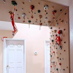 two elfs climbing up the side of a wall with candy canes on it