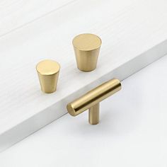 two brass knobs on the side of a white door