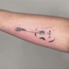 a man's arm with a guitar tattoo on it