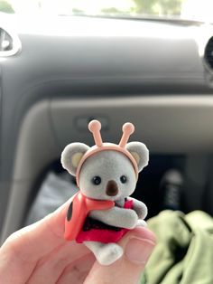 a person holding a small toy in their hand