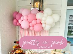 a table topped with lots of desserts and balloons next to a pink sign that says pretty in pink balloon kit