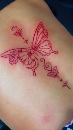 a butterfly tattoo on the back of a woman's left side ribcage