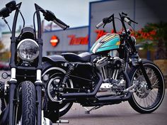 two motorcycles parked next to each other in front of a building with shops on it