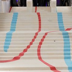 a group of people standing next to each other in front of stairs with red, white and blue lines painted on them