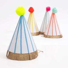 three party hats with pom poms on them