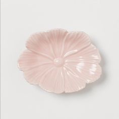 a pink flower shaped dish sitting on top of a white table