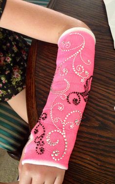 a woman with pink arm warmers on sitting at a table