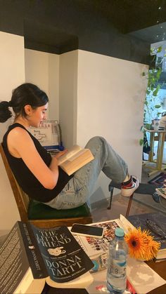 a woman sitting in a chair reading a book