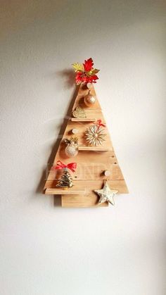 a wooden christmas tree hanging on the wall