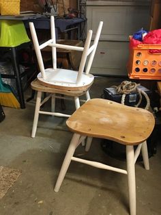 two wooden chairs sitting next to each other in a garage