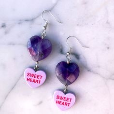 Gemstones are genuine amethyst metal is stainless steel earring wires are hypoallergenic Purple Metal Earrings For Gift, Purple Metal Earrings As Gift, Nickel-free Dangle Jewelry For Valentine's Day, Purple Double Heart Charm Jewelry, Trendy Dangle Crystal Earrings For Gifts, Trendy Crystal Dangle Earrings Gift, Purple Pierced Metal Jewelry, Purple Metal Pierced Jewelry, Purple Double Heart Jewelry With Heart Charm