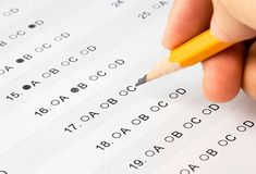 a hand holding a pencil over a test paper