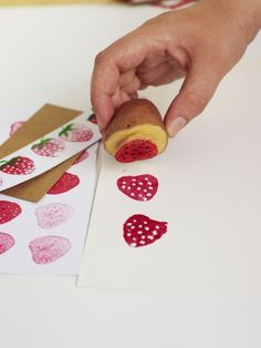 someone is making valentine's cards with fruit stamping on the paper and glue