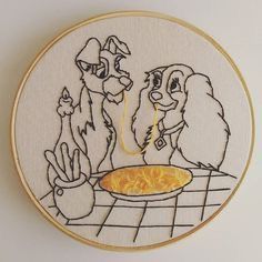 two dogs sitting at a table with a bowl of food in front of them on a hoop