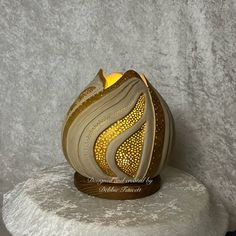 a decorative candle holder sitting on top of a white rock with a yellow light in the center