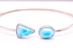 This gorgeous Dominican larimar bracelet will become your go to choice for accessorizing. This one is made with natural blue Dominican larimar set in sterling silver. These bracelets are flexible and can be twisted to slip on easily, at the same time they are durable enough for daily wear. They will fit small, medium or large wrists. Gemstones- Dominican Larimar Material : Sterling Silver See other items from my store here https://www.etsy.com/shop/GalantaJewels?ref=hdr_shop_menu Packaging : All products purchased from us come in a gift box. If you need to include a message, kindly leave us a note when purchasing.  Care Recommendations:  When not in use, keep earrings enclosed in a box or pouch to minimize exposure to moisture in air. Do not spray aromatics directly onto product. Minimize Larimar Bracelet Jewelry Gift, Handmade Adjustable Larimar Bracelets, Turquoise Larimar Bracelet, Turquoise Larimar Bracelets For Gifts, Turquoise Larimar Bracelets As A Gift, Adjustable Blue Larimar Jewelry, Elegant Turquoise Larimar Bracelets, Turquoise Larimar Natural Stone Bracelets, Blue Larimar Hypoallergenic Jewelry