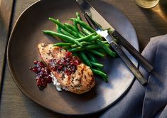 a plate with meat, green beans and cranberry sauce next to a fork