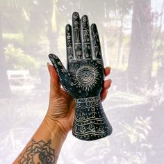 a person holding up a black and white hand with an eye design on the palm