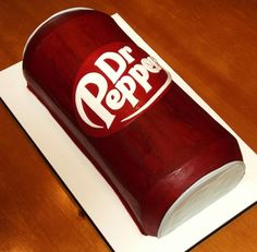 a cake made to look like a book with a dr pepper logo on the cover