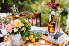 the table is set with flowers, books and candles for an intimate dinner or celebration