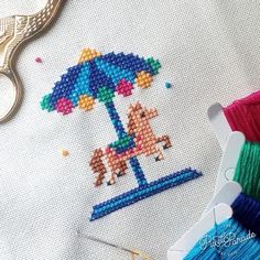 the cross stitch pattern is being worked on with scissors