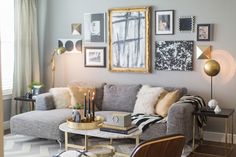 a living room filled with furniture and pictures hanging on the wall above it's coffee table