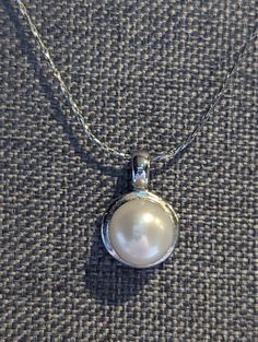 "Fine Pearl Pendant necklace featuring large 9mm white Pearl set in a 18k White Gold Plate pendant. Chain is solid 18k White Gold. This would make a lovely wedding necklace. HALLMARKS Chain is hallmarked 18k and test as such. Pendant is 18k GP. MEASUREMENTS 16\" long chain with 5/8\" x 3/8\" pendant. CONDITION In very good to excellent condition, please use all pictures as part of item's description. MATERIALS 18k White Gold (Chain) 18k White Gold Plate, Genuine 9mm Pearl. CLOSURE Spring ring cl Classic White Gold Hallmarked Bridal Necklace, Classic White Gold Bridal Necklace, Elegant Formal Necklace With Polished Finish, Formal Hallmarked Round Necklace, Classic Necklace With Polished Round Pendant, Classic Necklaces With Polished Round Pendant, Classic Necklaces With Round Pendant And Polished Finish, Classic Round Pendant Necklace With Polished Finish, Elegant Pearl White Necklaces For Formal Occasions