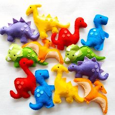 there are many different colored toy dinosaurs on the table