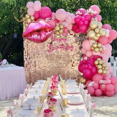 a table topped with lots of pink and gold balloons