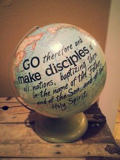 a globe with writing on it sitting on top of a wooden table