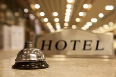 a hotel bell sitting on top of a counter in front of a sign that reads hotel