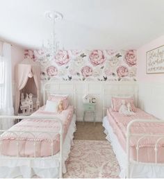 two twin beds in a girls room with pink and white wallpaper on the walls