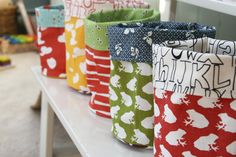 several fabric storage bins lined up on a table with the words round bottomed