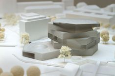 a model of a building surrounded by white flowers