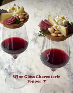 two wine glasses with different types of food in them