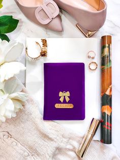 a purple book sitting on top of a table next to some flowers and other items