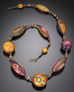 a multicolored beaded necklace on a black surface