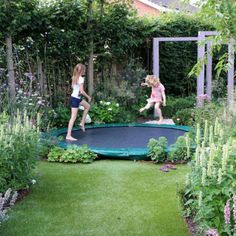 two girls jumping on a trampoline in a garden