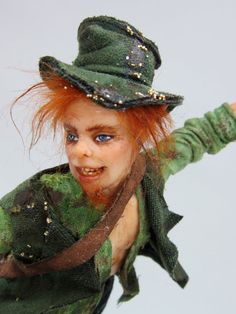 a doll with red hair wearing a green hat