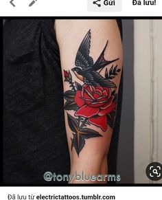 a woman's arm with a bird and rose tattoo on it