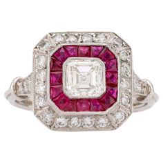 Center Stone: Asscher Cut Diamond Weight: Approximately .55 Carat Color: I Clarity: VS Accent Stone: 16 Calibre French Cut Rubies Weight: Approximately .60 Carats Accent Stone: 24 Round Brilliant Cut Diamonds Weight: Approximately .50 Carats Color: H Clarity: VS Metal: Platinum Era: Modern Circa: 2020's in The Style of Art Deco Size: 6.25 and can be resized Gram weight: 4.76 This stunning Art Deco-inspired ring, crafted in platinum, showcases a dazzling .55 carat Asscher cut diamond at its center, graded I in color and VS in clarity. Surrounding the diamond are 16 vivid calibre French cut rubies, totaling approximately .60 carats, which form a striking square halo. Accentuating the design are 24 round brilliant cut diamonds, adding another .50 carats of sparkle, with H color and VS clarity Square Halo Ring, Marquise Diamond Engagement Ring, Cognac Diamonds, Art Deco Diamond Rings, French Cut, Ruby Engagement Ring, Art Deco Engagement, Dream Engagement, Deco Engagement Ring