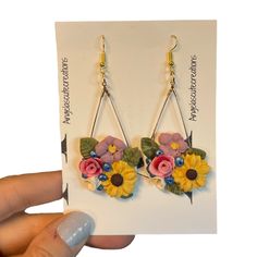 There Are Two Pairs Available, Both Are Pictured. When Ordered You Will Receive 1, Of The Pairs, They Are Very Similar These Are Handmade, By Me. They Have A Violet Purple, Or Lavender Flower With Yellow Center Red, Pink Handrolled Rose, Yellow And Brown Sunflower, Hand Rolled White Lilly With Yellow Center, And Metallic Blue Blooms, Or Blueberries. These Earrings Weigh In At 0.401 Oz’s For Weight. So You Are Pretty Lightweight. The Have Fishhook Dangles Wire And Are Based On A Teardrop Gold Tan Yellow Flower Charm Earrings For Spring, Yellow Dangle Flower Earrings For Spring, Handmade Flower Earrings Adjustable For Spring, Yellow Spring Jewelry With Flower Decoration, Spring Yellow Jewelry With Flower Decoration, Yellow Jewelry With Flower Decoration For Spring, Spring Multicolor Floral Print Flower Earrings, Handmade Yellow Flower Earrings, Yellow Flower-shaped Earrings With 3d Flowers