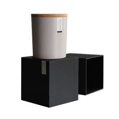 a white cup sitting on top of two black boxes