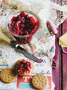 a jar of jam next to two cookies on a table