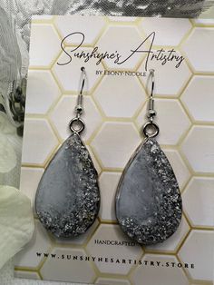 the earrings are made from silver and black drusby stone, which has been handcrafted by sunflower artisans