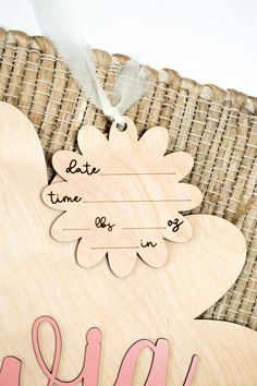 a close up of a wooden sign with the word mom on it and a flower