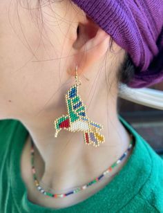 a close up of a person wearing a pair of earrings and a purple headband