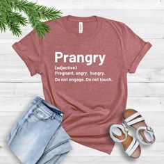 a t - shirt with the words prangy on it next to some shoes