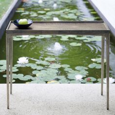 a table that has some water lilies on it and a bowl sitting on top